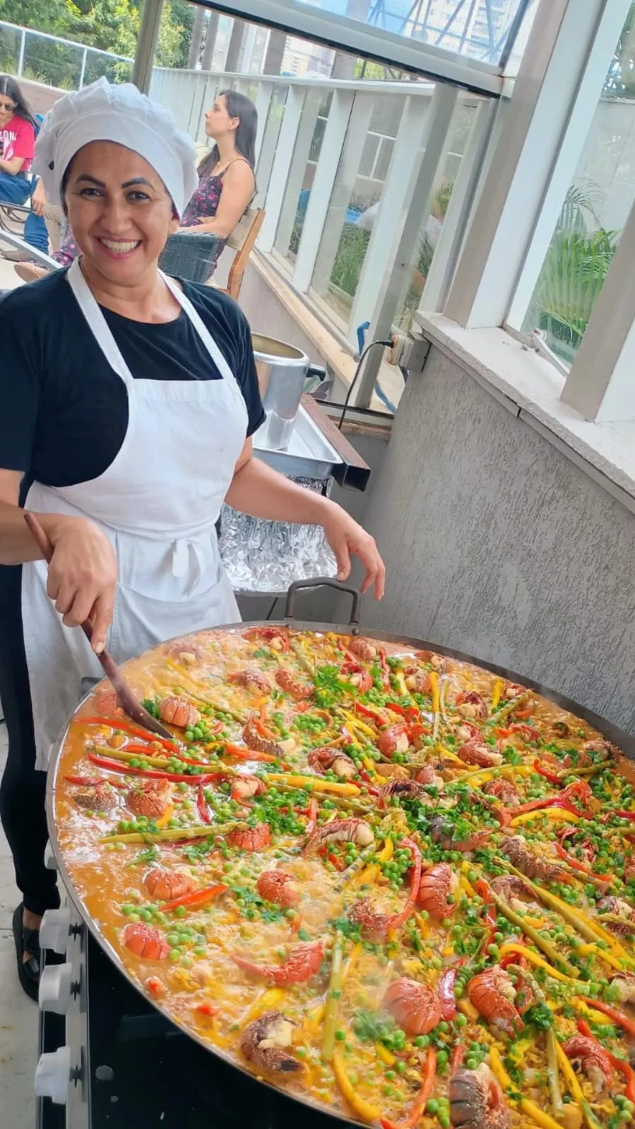 Veri preparando uma paella em um evento